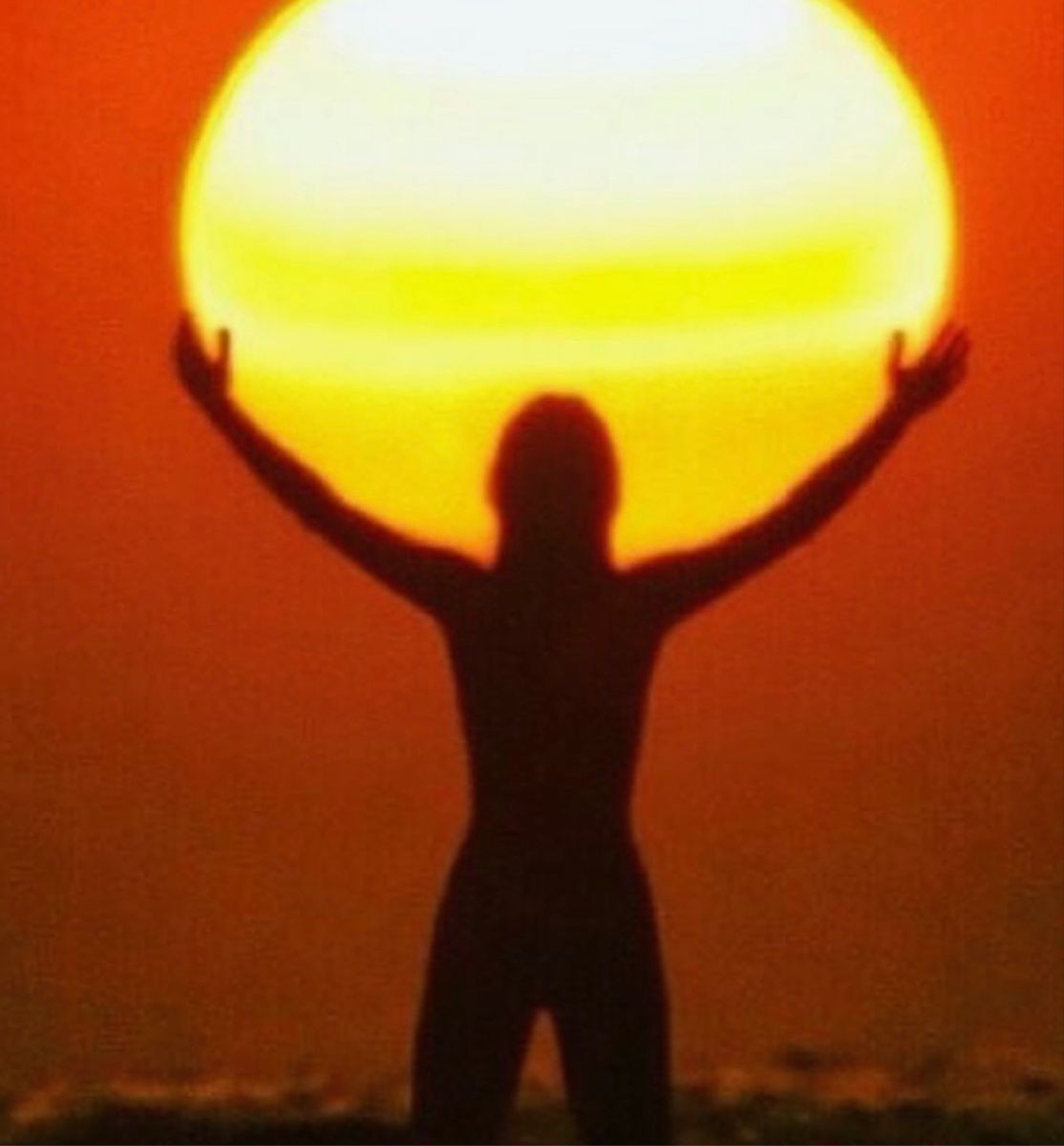 Silhouette holding up the sun